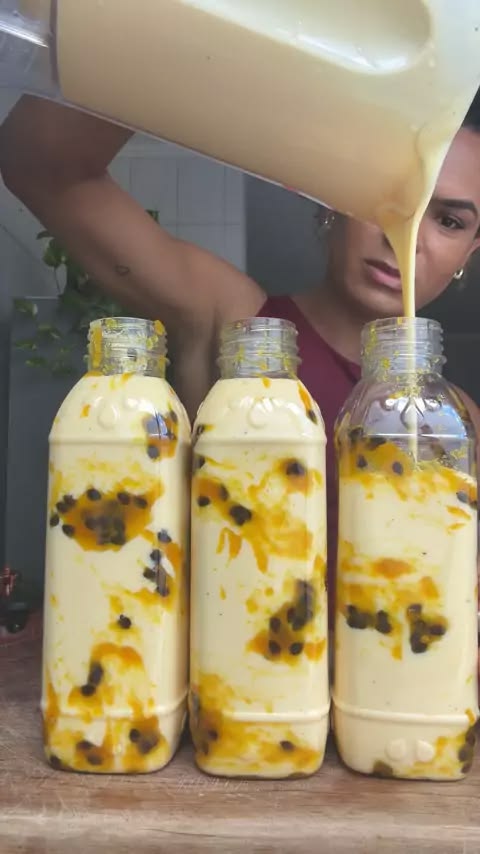 Garrafinhas de mousse de maracujá sendo preenchidas